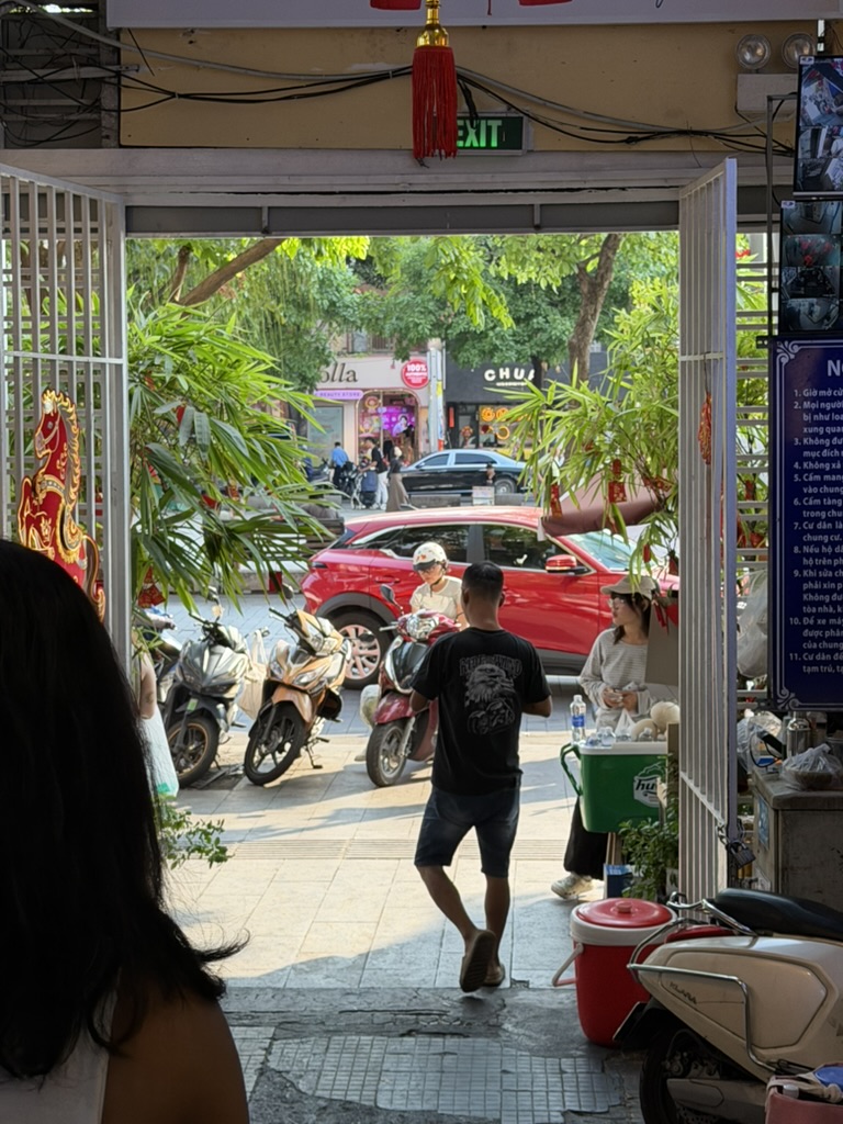 Street life framed through a shophouse doorway